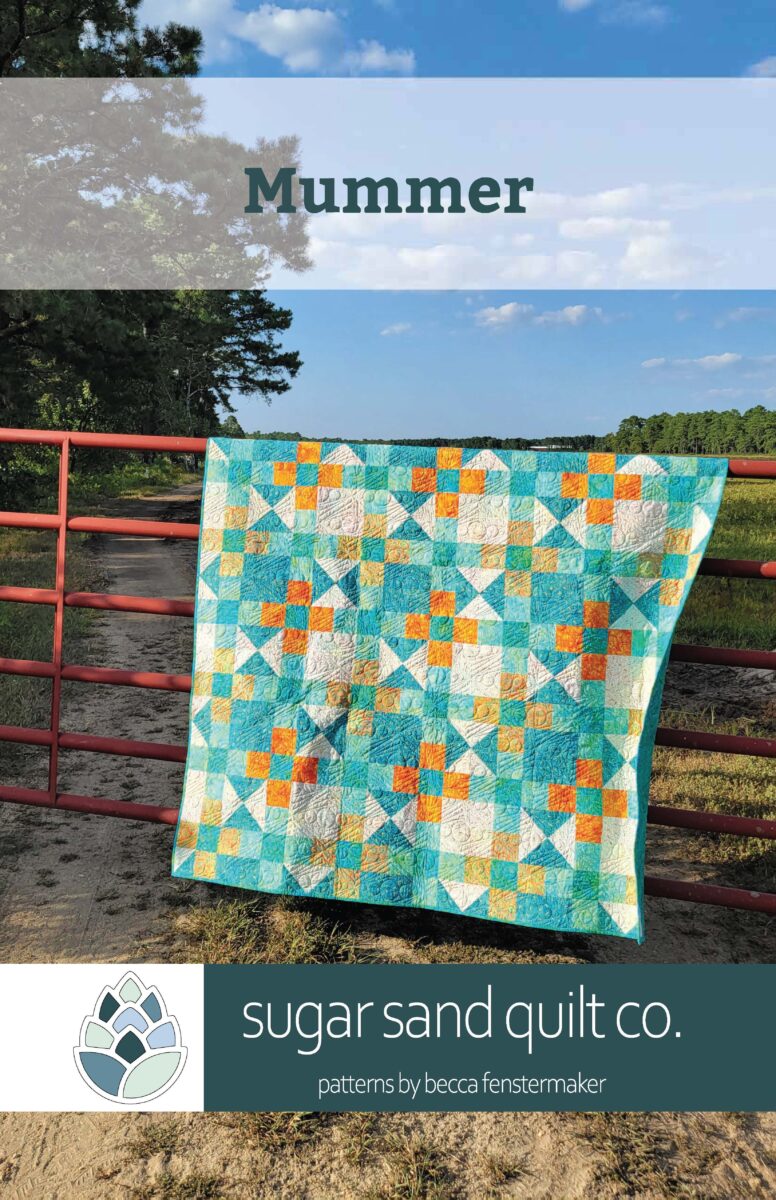 photo of a quilt draped over a red gate with a banner title that says Mummer